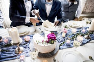 same-sex couple cutting wedding cake